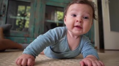 Bebek içeride yatıyor, merakla yan tarafa bakıyor, erken gelişim evresi, mide zamanı, büyüme farkındalığı, meşgul yüz ifadesi, ev dekorasyonu.