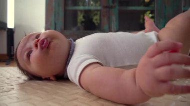 Bebek minderli mindere uzanır, elini öne uzatır, ağzı hafifçe açılır, bacakları bükülür, gevşer ve çevresine bağlanır, erken gelişim, oyuncu ve meraklı bir an
