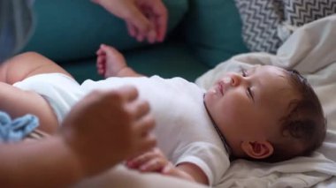 Anne bebeğe yakın duruyor, samimi bir bağ kurma anı, sevgi dolu bakışlar, güçlü ebeveyn-çocuk bağı, sıcaklık, bakım, sevgi, huzur dolu ev atmosferi..