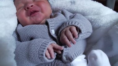 Örgü bir süveter içinde ağlayan yeni doğmuş bir bebek, çocukluk anılarının doğal ve ham duygularını vurguluyor..