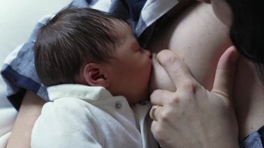 Bir annenin yeni doğmuş bebeğini emzirdiği, yakın bağın altını çizdiği ve huzurlu, samimi bir yuvanın bakımını üstlendiği hassas bir an..