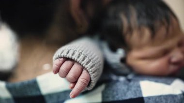 Emzirdikten sonra anne omzunda huzur içinde dinlenen yeni doğmuş bir bebeğin yakın çekimi, anne ile çocuk arasındaki hassas bağı ve sıcaklığı gösteriyor..