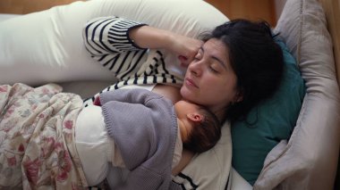 Bir annenin yeni doğmuş bebeğinin göğsünde uyuduğu huzurlu bir an. Her ikisi de samimi ve samimi bir atmosferle çevrili. Bağlarındaki saf sevgi ve huzuru temsil ediyor.