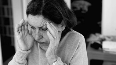 Şiddetli baş ağrısı olan yaşlı bir kadın, elleri şakaklara baskı yapıyor, derin konsantrasyon ve zihinsel gerginlik. Yaşlanan cilt ve yüz hatları, stres yoğunluğu, duygusal acı-SD 480p