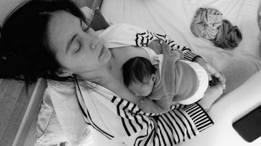 Anne, yeni doğmuş bebeğini göğsünde dinlendirirken, erken anneliğin huzurunu ve derin bağını yakalıyor. anne ve çocuk arasındaki tek renkli barışçıl bağ.