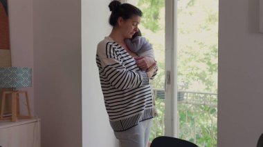 Anne ve küçük oğlu pencerenin kenarında yan yana duruyor, sessiz bir bağlantı ve yansıma anını paylaşıyorlar. Aile bağlarının şefkati ve birlikte olmanın rahatlığı.