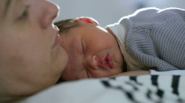 Yeni doğan bebek anne göğsünde dinleniyor. Huzur içinde uyuyor. Ebeveyn ve çocuk arasındaki derin bağı ve sevgiyi simgeliyor.