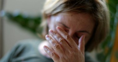 Endişeli yaşlı kadın inançsızlıkla tepki veriyor. Gözü elle ovuyor.