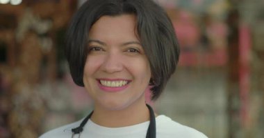 Çiçekçi dükkanının dışındaki gülümseyen çiçekçiyi, neşeli ifadeyi ve çiçekçilik işindeki mesleki tavırları kapatın.