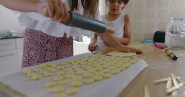 Kız ve erkek mutfaktan para kazanıyor, kız oklava kullanıyor, oğlan asistanı, aile yemekleri, takım çalışması, parlak ev dekorasyonu, öğrenme ve bağ kurma ile uğraşan çocuklar