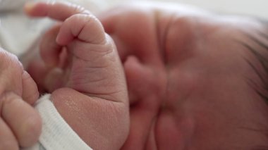 Küçük el hareketleri ve bebeğin yüzünde hafif bir ekşitme ile yeni doğmuş bir bebeğin uykusunda hareketli yakın çekimi
