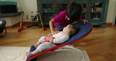 Büyük kardeş, bir fedainin içindeki küçük kardeşle kibarca iletişim kuruyor, şefkatli ve sevgi dolu bir aile anı yaratıyor, bir yuva ortamındaki kardeşler arasındaki güçlü bağı ve sevgiyi gösteriyor.