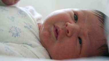 Yeni doğmuş bir bebeğin, ilk ayın karakteristik özellikleri olan, merakla hareket eden ve somurtan ve hareket eden görüntüsü, erken yaşam temaları için mükemmel.