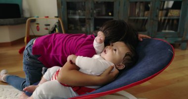 Büyük kardeş, bir fedainin üzerindeki küçük kardeşle şefkatle iletişim kuruyor. Bir yuva ortamında aralarındaki güçlü bağı ve sevgiyi vurgulayan dokunaklı ve sevgi dolu bir an yaratıyor.