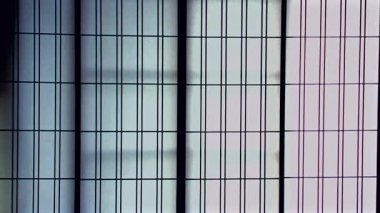 Dikey Shoji kağıdı ahşap şebeke çerçeveli kapıları geleneksel Japon iç kısımlarında, kağıt panellerden süzülen yumuşak yayılmış ışık sakin bir ortam yaratıyor.