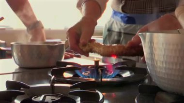 Eller ocakta açık gaz ocağında yemek kızartıyor, ev mutfağında kömürleşme işlemi, geleneksel yemek pişirme tekniği, yemek hazırlama, ızgara, mutfak sahnesi