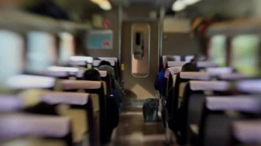 Yolcularla dolu bir tren vagonunun içinde, koridorun aşağısına bakıyor, seyahat sahnesini çekiyor ve toplu taşıma araçlarıyla seyahat ediyor.
