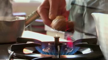 Eller bir parça yiyeceği ocağın üstünde kızartıyor, ocakta kömürleşme ve pişirme işlemi, ızgara tekniği, ev mutfağı hazırlığı, doğrudan ateş pişirme.