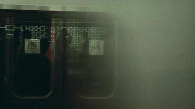 Metro treninin camlarından siluetler, şehir içi ulaşımın hareket bulanıklığı, camlardaki yansımalar, şehir ulaşımı sahnesi, modern metropol hayatı, soyut bakış açısı.