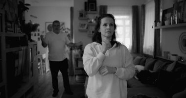 Kadın hararetli tartışmalar sırasında derin düşüncelere dalarken, arka plandaki erkek hayal kırıklığı, gerginlik ve bir çift ilişkisindeki çözülmemiş sorunları vurguluyor..