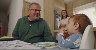 Babam gülümseyerek ve karnını doyurarak sandalyeye oturmuş, sıcak bir ev mutfağında yemek masasında eğlenceli bir ilişkiye giriyordu.