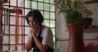 Kır çiçekçisinin içinde sessizce oturan kadın çiçekçi, küçük işletme sahibi düşünceli ve iş güçlüklerinden bunalmış hissediyor.