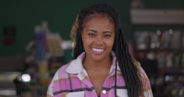 Markette gülümseyen Afrikalı Amerikalı bir kadının yakın plan portresi, alışveriş arabalarının yanında duruyor, neşeli bir ifade, piyasa geçmişi...