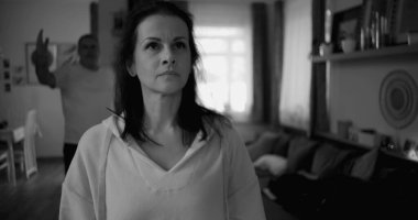 Kadın hararetli tartışmalar sırasında yüzünü geri çeviriyor. Arka plandaki adam duygusal hareketler yapıyor. Gerilime ve gergin ilişki dinamiklerine odaklanıyor..