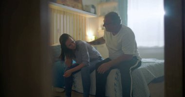 Kocası üzgün karısına destek oluyor, yatağın kenarında oturuyor, duygusal mücadeleye odaklanıyor, zihinsel sağlık farkındalığı, umutsuzluk, üzüntü ve kişisel kriz temaları