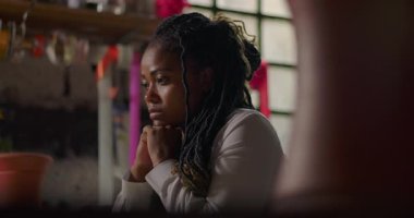 Kırsal kesimdeki çiçekçide dalgın dalgın oturan bayan çiçekçi, küçük işletme sahibi zorlukları, esnekliği ve gelecekteki büyüme olasılıklarını yansıtıyor