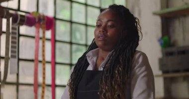 Kırsal çiçekçi dükkanında başı öne eğik bir bayan çiçekçi, küçük işletme sahibi yorgun ve duygusal yorgunlukla çalışıyor.