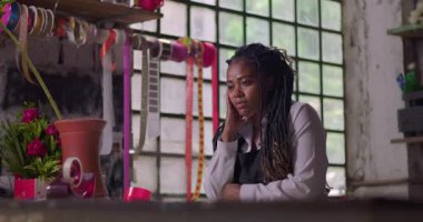 Çiçekçinin içinde derin düşünen kadın çiçekçi, küçük işletme sahibi gelecek planları, iş stratejisi ve yeni yaratıcı fikirler düşünüyor.