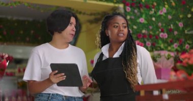 Çiçekçiler, çiçekçi dükkanında iş birliği yapıyorlar, fikir alışverişinde bulunuyorlar ve iş planları üzerinde çalışıyorlar.