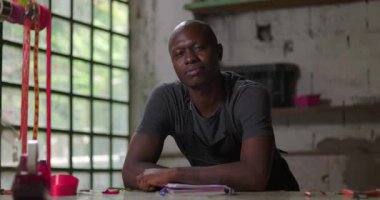 Çiçekçi kollarını tezgahta dinlendiriyor. Kırsal kesimdeki çiçekçi dükkanında düşünceli görünüyor. Küçük işletme sahibi gelecek planlarını ve fırsatlarını düşünüyor.