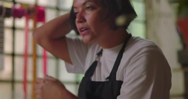 Çiçekçi kadın gözyaşlarını siliyor ve kırsal çiçekçi dükkanında duygusal duygular hissediyor. Küçük işletme sahibi üzüntü, yorgunluk ve kişisel mücadeleyle uğraşıyor.