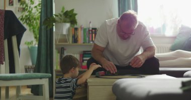 Baba, kahve masasında oyuncak tren oyunu oynayan çocukla karşılaşır. Baba ve oğul arasında samimi bir bağ kurar. Sakin ve sıcak bir oturma odası kurar.