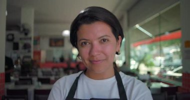 Lokantanın içindeki portrede hafifçe gülümseyen Latin garson kendinden emin ve dostane bir ifadeyle doğrudan kameraya bakıyor.