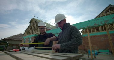Ahşap, takım çalışması ve doğruluğu işaretleyen iki inşaatçıya yakın çekim, ev yapımı, konut projesi devam ediyor, kalın şapkalar, aletler ve malzemeler ile çalışabilir-SD 480p.mov