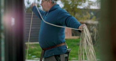 İnşaat sahasında miğferi olan işçilere kablo taşıyıp düzenlemek, el işçiliği ve dışarıda profesyonel aktiviteler sergilemek.