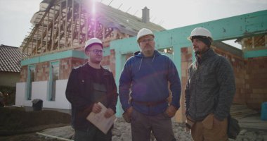 İnşaat ekibi inşaat alanının planlarını, takım çalışmasını ve koordinasyonunu, proje detayları, yönetim ve inşaatta planlama üzerine çalışan profesyonelleri tartışıyor