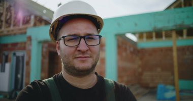 İnşaat işçilerinin sabit şapkalı, ciddi ve odaklı ifadeli yakın çekimi, inşaat alanında inşaat profesyoneli, kaliteye adanmış ve proje başarısı