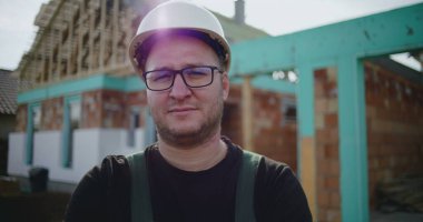 İnşaat işçilerinin sabit şapkalı, ciddi ve odaklı ifadeli yakın çekimi, inşaat alanında inşaat profesyoneli, kaliteye adanmış ve proje başarısı