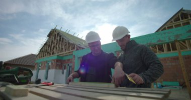 Ahşap, takım çalışması ve doğruluğu işaretleyen iki inşaatçıya yakın çekim, ev yapımı, konut projesi devam ediyor, kalın şapkalar, aletler ve malzemeler ile çalışabilir-SD 480p.mov