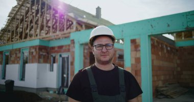 İnşaat alanında sağlam şapkalı inşaat işçisi, inşaat projesine odaklanmış, endüstride deneyimli, kaliteli işe adanmış.