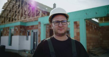 İnşaat alanında sağlam şapkalı inşaat işçisi, inşaat projesine odaklanmış, endüstride deneyimli, kaliteli işe adanmış.