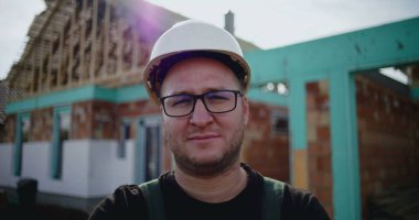 İnşaat işçisi inşaat alanında kollarını kavuşturmuş, inşaat sektöründe kendine güvenen, sorumluluk sahibi ve gururlu bir inşaat işçisi, devam etmekte olan bir proje.