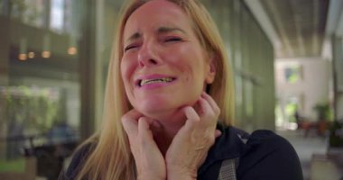 İki eliyle yüzünü tutan bir kadın, gözyaşı dolu bir ifade, hüzünle dolu duygusal bir anda gözlerini sımsıkı kapatan bir kadın veya kapalı bir yerde kişisel bir keder.