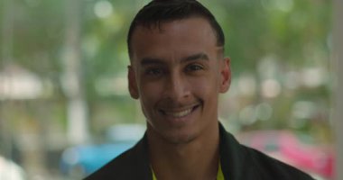 Gündelik restoran içinde gülümseyen Latin Amerikalı adama yakın plan, yumuşak arkaplanlı samimi ve cana yakın ifade