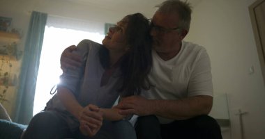 Karı koca gözyaşlarına boğulurken onu kucaklıyor, umutsuzluk anında duygusal destek sunuyor, sevgi, empati, zihinsel sağlık sorunları ve bağlantı temaları