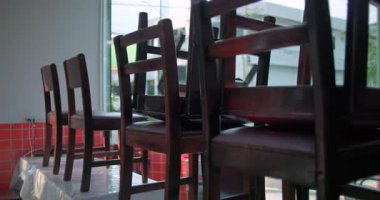 Kapanış saatinde restoranın içindeki masaların üzerine tepetaklak duran tahta sandalyeler, servisi sonlandırma ve temizlik hazırlıklarını yansıtıyor.